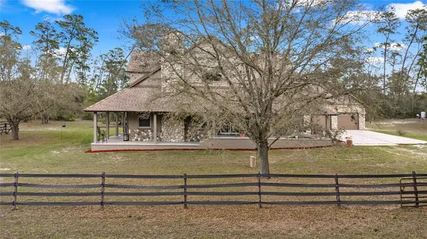 a white house that has a tree in front of it