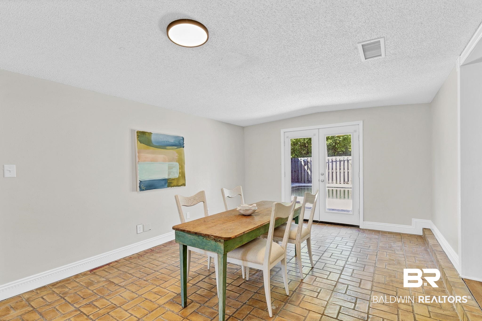 11964 Stroh Road Daphne, AL 36527 - Photo 22 of 58 Dining space featuring brick floor, baseboards, visible vents, and a textured ceiling