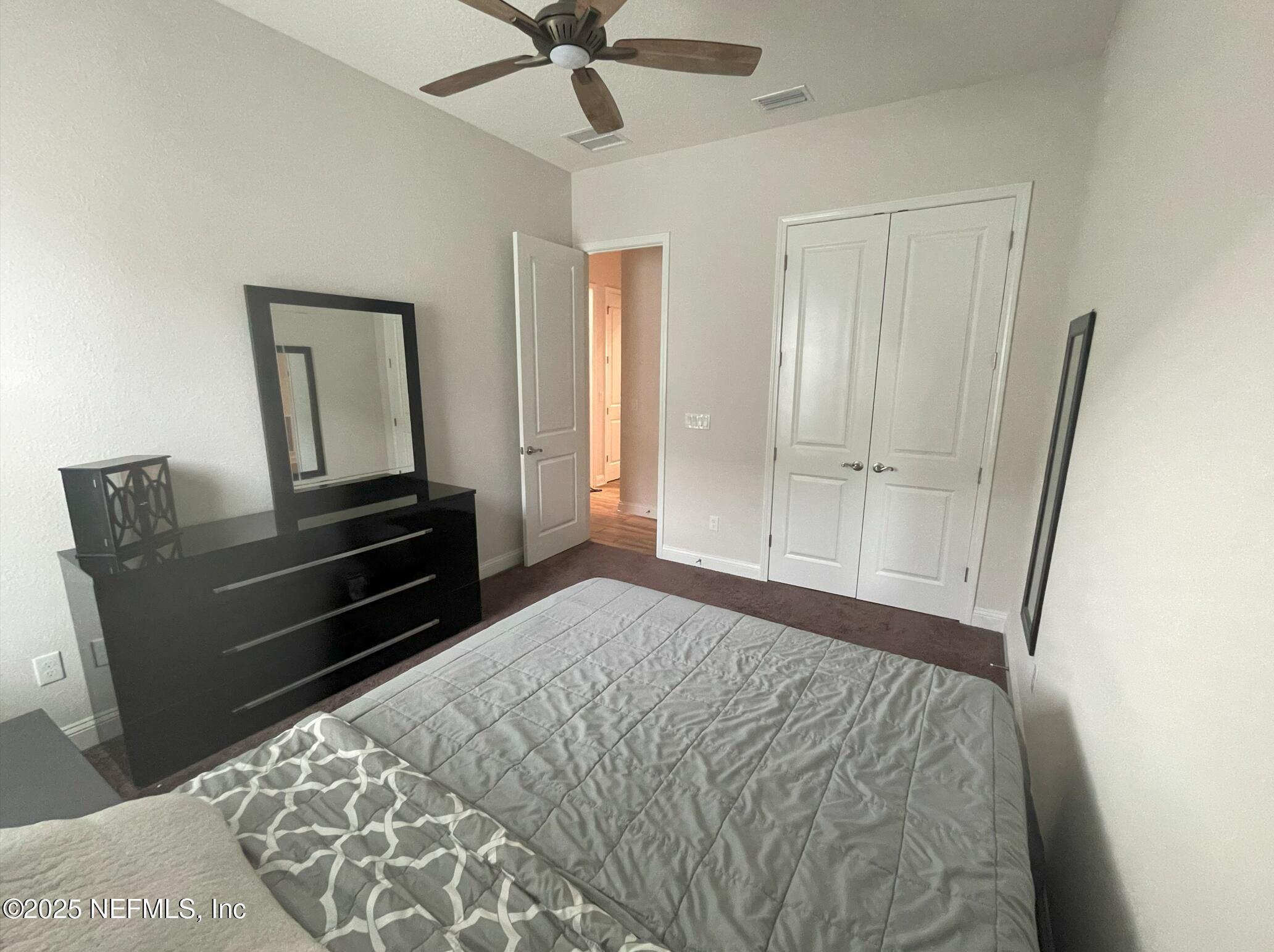2489 Caprera Circle Jacksonville, FL 32246 - Photo 11 of 23 a bedroom with a bed and a chandelier