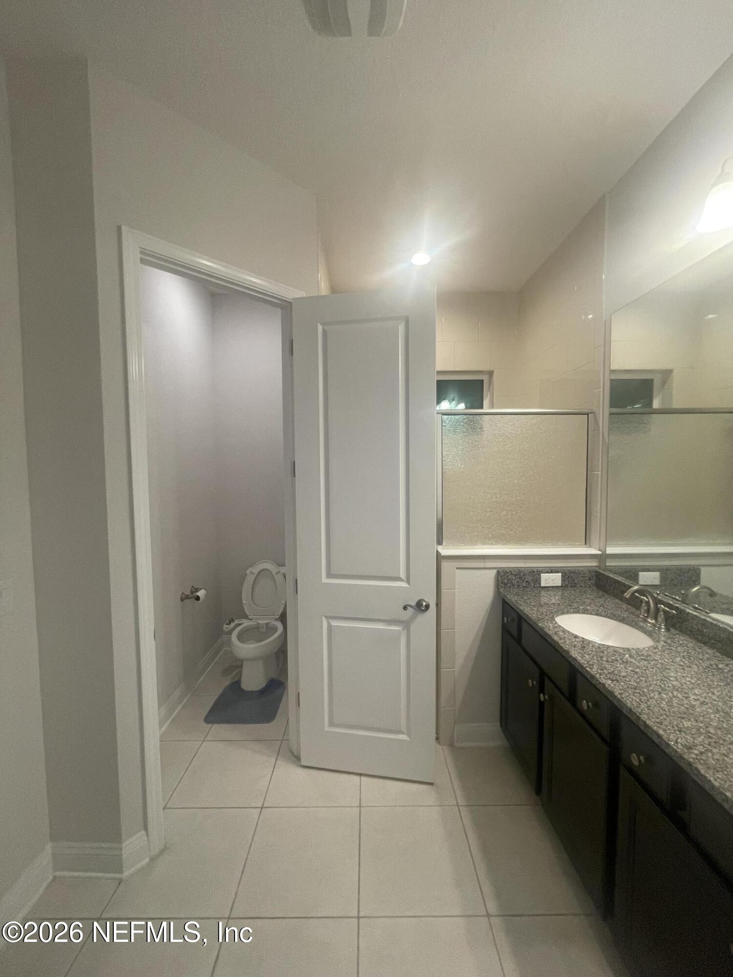 2489 Caprera Circle Jacksonville, FL 32246 - Photo 14 of 23 a bathroom with a granite countertop sink a toilet and a mirror