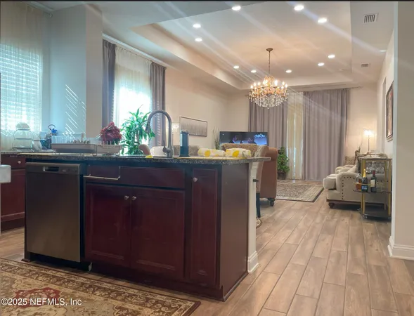 a kitchen with kitchen island granite countertop a sink cabinets and wooden floor