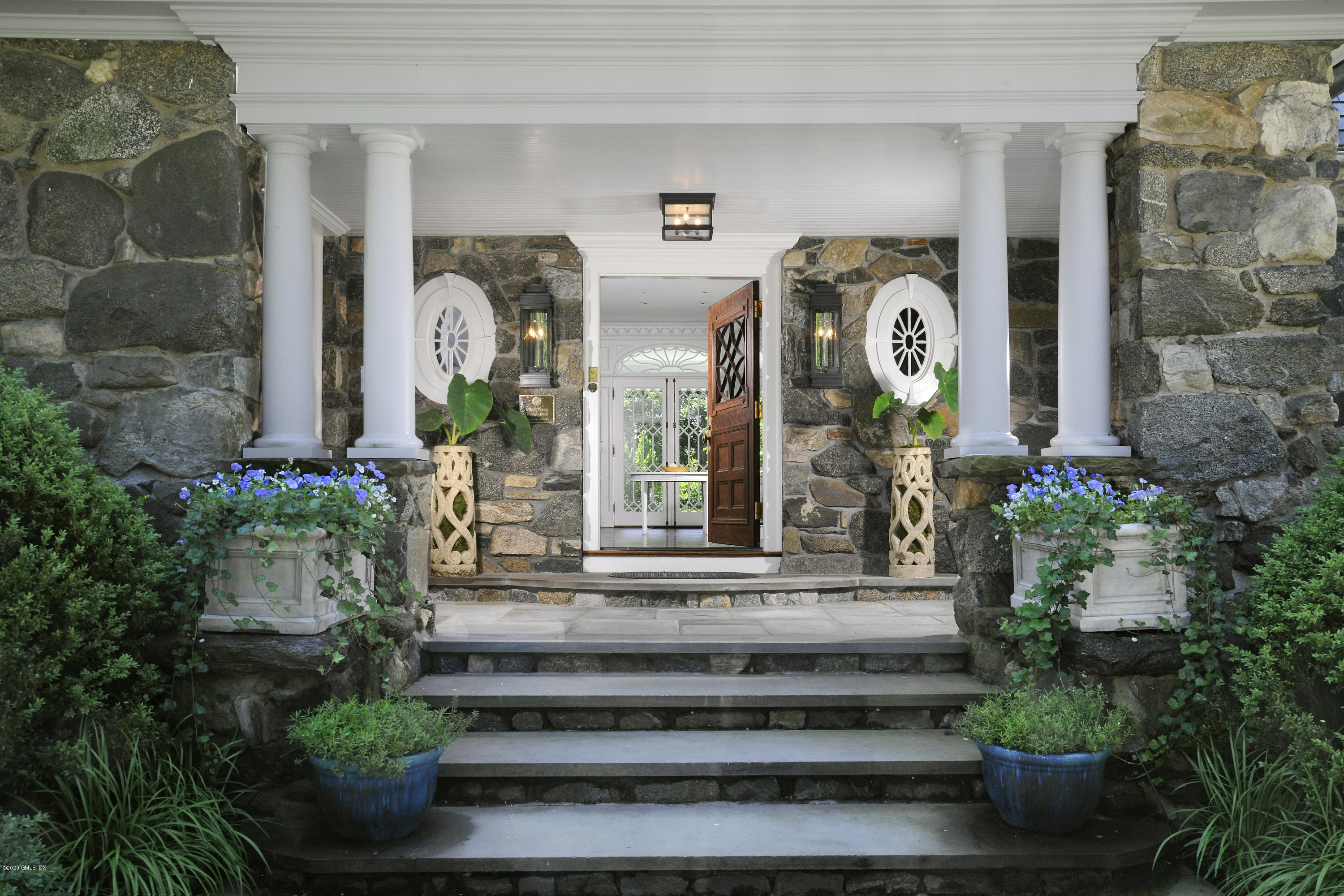 31 Rock Ridge Avenue Greenwich, CT 06831 - Photo 2 of 44 a front view of a house with potted plants