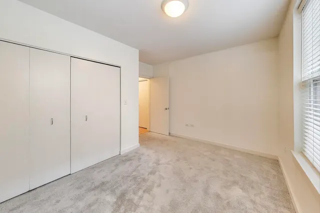 an empty room with windows and closet