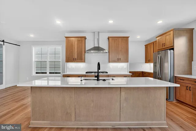 a kitchen with stainless steel appliances granite countertop a sink and a refrigerator