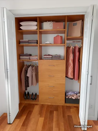 a view of walk in closet with clothes and shoes