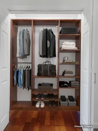 a view of walk in closet with clothes and shoes