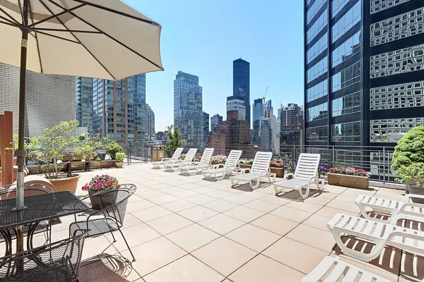 a view of a patio with dining table and chairs and potted plants