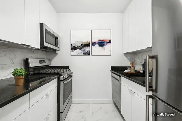 a kitchen with stainless steel appliances granite countertop white cabinets and black stove next to a window