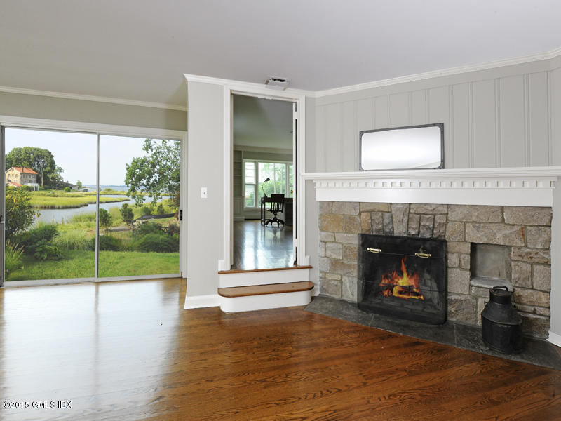 8 Indian Point Lane Riverside, CT 06878 - Photo 6 of 18 a living room with a fireplace and a floor to ceiling window