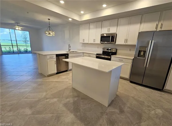 a kitchen with a sink a microwave a refrigerator and cabinets
