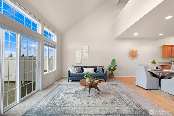 a living room with furniture a rug and a floor to ceiling window