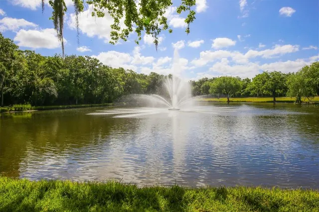 a view of a lake with a floor to ceiling window next to a yard