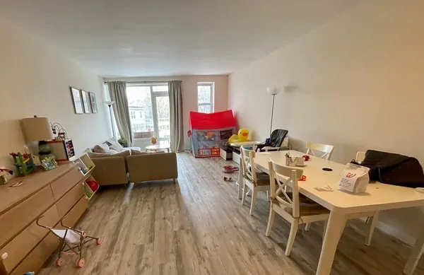 a living room with furniture a couch and a dresser next to a window