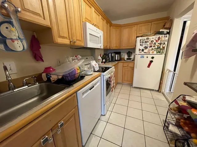 a kitchen with a sink a refrigerator and cabinets