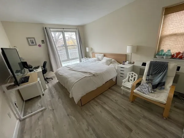 a bedroom with a bed a couch and windows