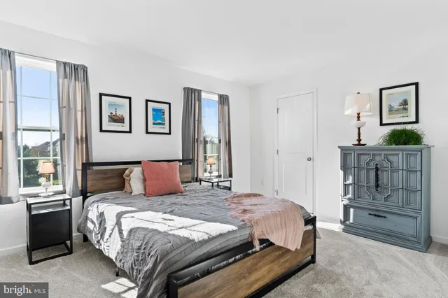 a bedroom with a bed and a lamp on dresser