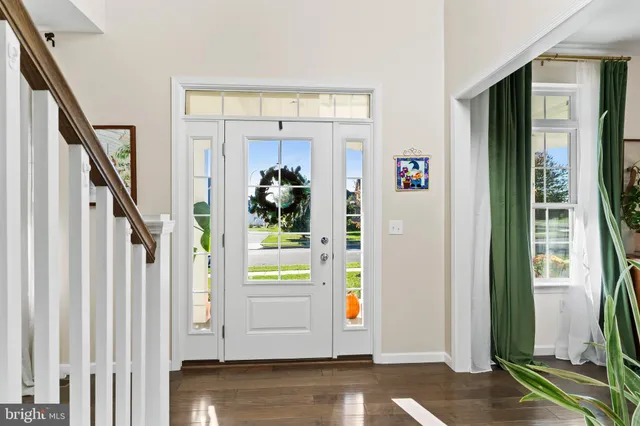 a view of a dining room and livingroom with furniture wooden floor a chandelier