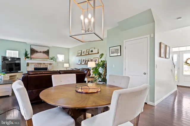 a kitchen with stainless steel appliances kitchen island granite countertop a refrigerator a stove oven a sink dishwasher and white cabinets with wooden floor