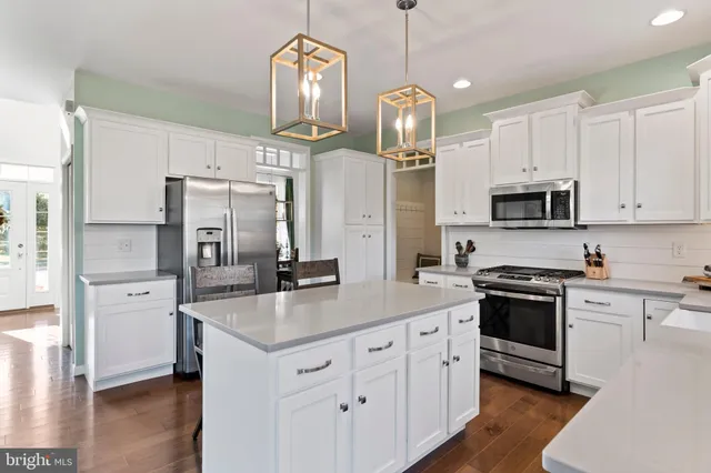 a kitchen with white cabinets and appliances