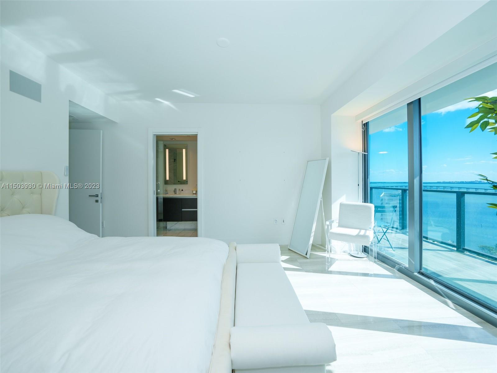 1451 Brickell Avenue, Unit 1803 Miami, FL 33131 - Photo 16 of 35 a bedroom with a bed and a large mirror