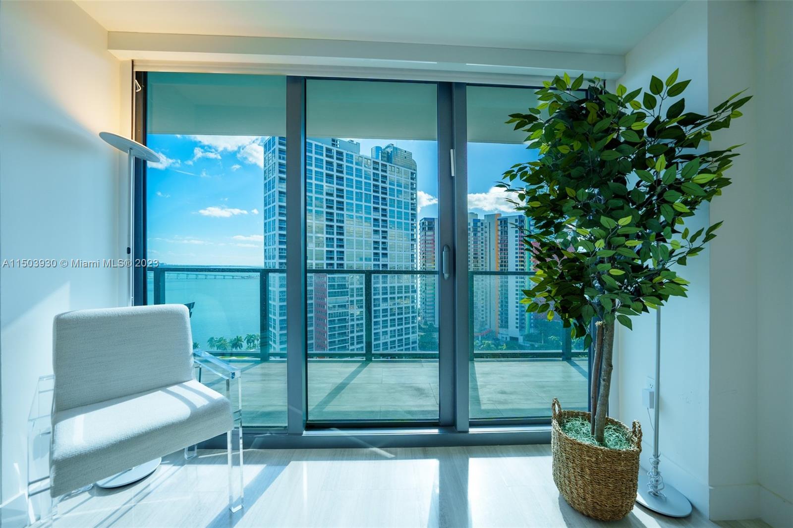 1451 Brickell Avenue, Unit 1803 Miami, FL 33131 - Photo 24 of 35 a potted plant sitting in front of a glass door