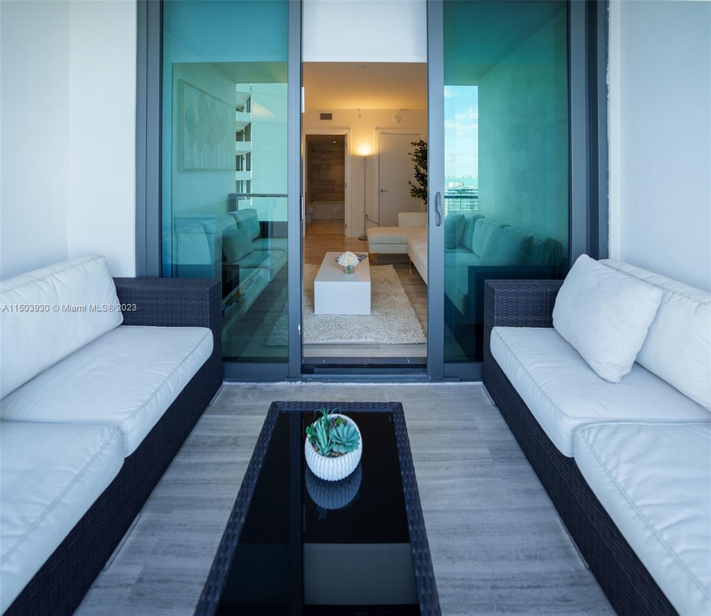 1451 Brickell Avenue, Unit 1803 Miami, FL 33131 - Photo 34 of 35 a living room with furniture and a wooden floor