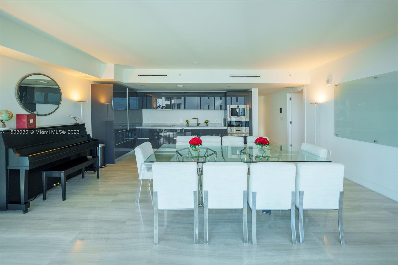 1451 Brickell Avenue, Unit 1803 Miami, FL 33131 - Photo 10 of 35 a living room with furniture a dining table and paintings on the wall