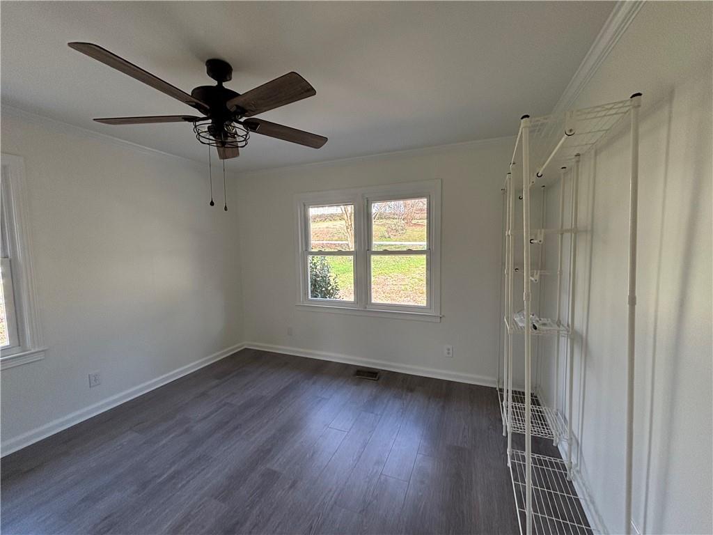 3854 Davis Street Suwanee, GA 30024 - Photo 12 of 24 a view of a livingroom with a hardwood floor a ceiling fan and windows