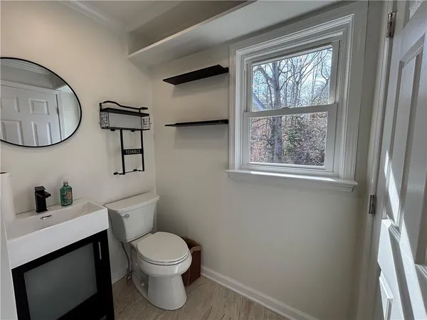 a bathroom with a toilet a sink and a window