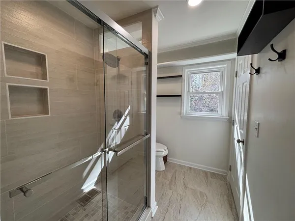 a bathroom with a toilet and a shower