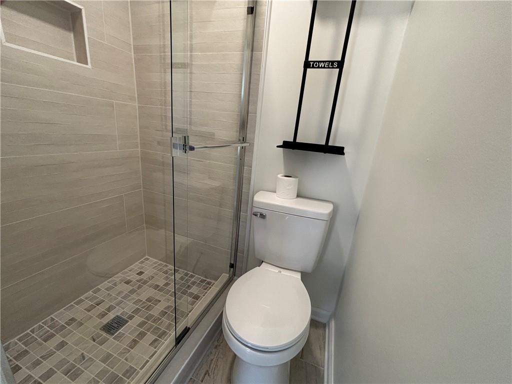 3854 Davis Street Suwanee, GA 30024 - Photo 16 of 24 a white toilet sitting next to a bathroom sink