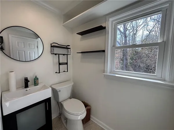 a bathroom with a toilet a sink and a mirror