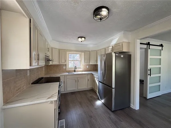 a kitchen with a refrigerator a sink dishwasher a stove and a refrigerator with wooden floor