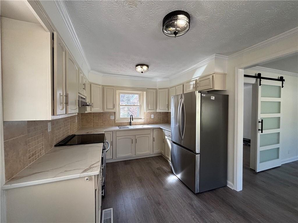 3854 Davis Street Suwanee, GA 30024 - Photo 8 of 24 a kitchen with a refrigerator a sink dishwasher a stove and a refrigerator with wooden floor