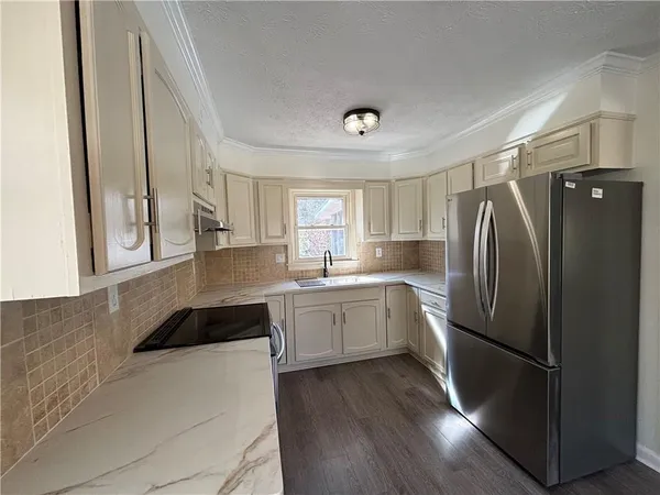 a kitchen with a refrigerator a sink and cabinets