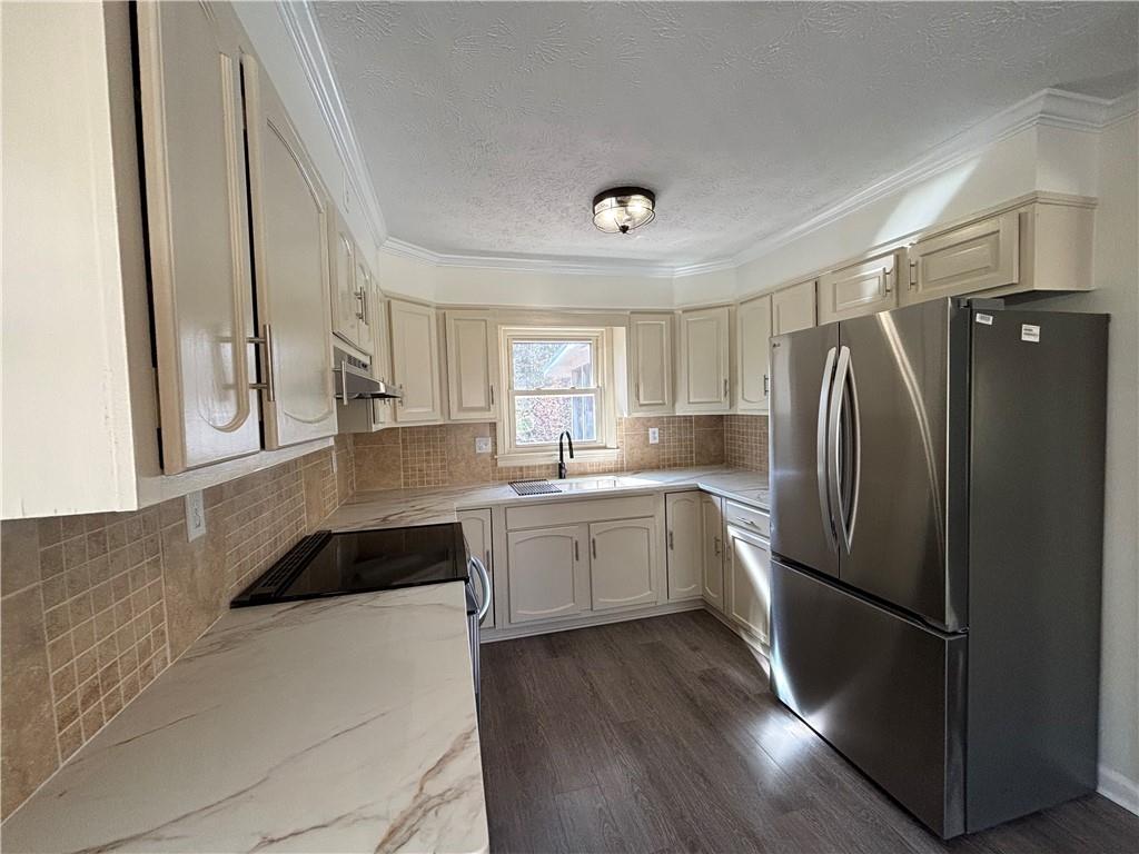3854 Davis Street Suwanee, GA 30024 - Photo 10 of 24 a kitchen with a refrigerator a sink and cabinets