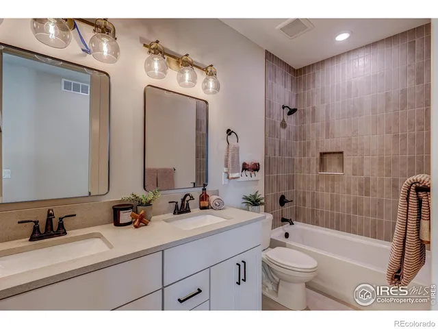 a bathroom with a sink a toilet a mirror and shower