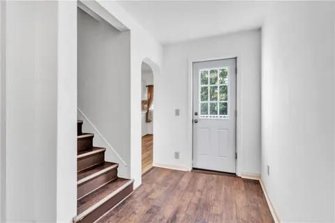 an empty room with wooden floor and entryway