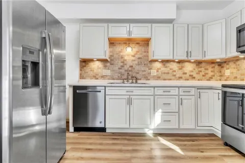 a kitchen with white cabinets and refrigerator