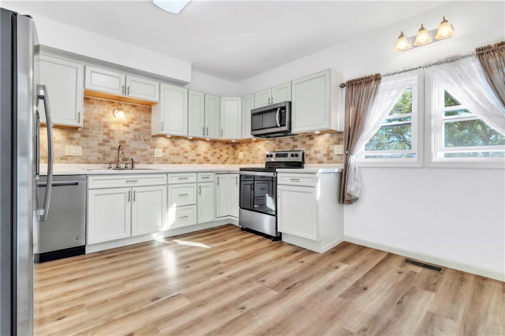 841 Railroad Street McKees Rocks, PA 15136 - Photo 15 of 44 a kitchen with a sink white cabinets and white appliances