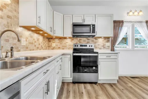 a kitchen with a sink stove and microwave