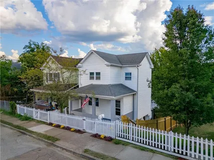 a view of a house with wooden fence next to a road