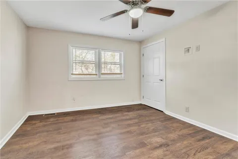 an empty room with a window and a fan