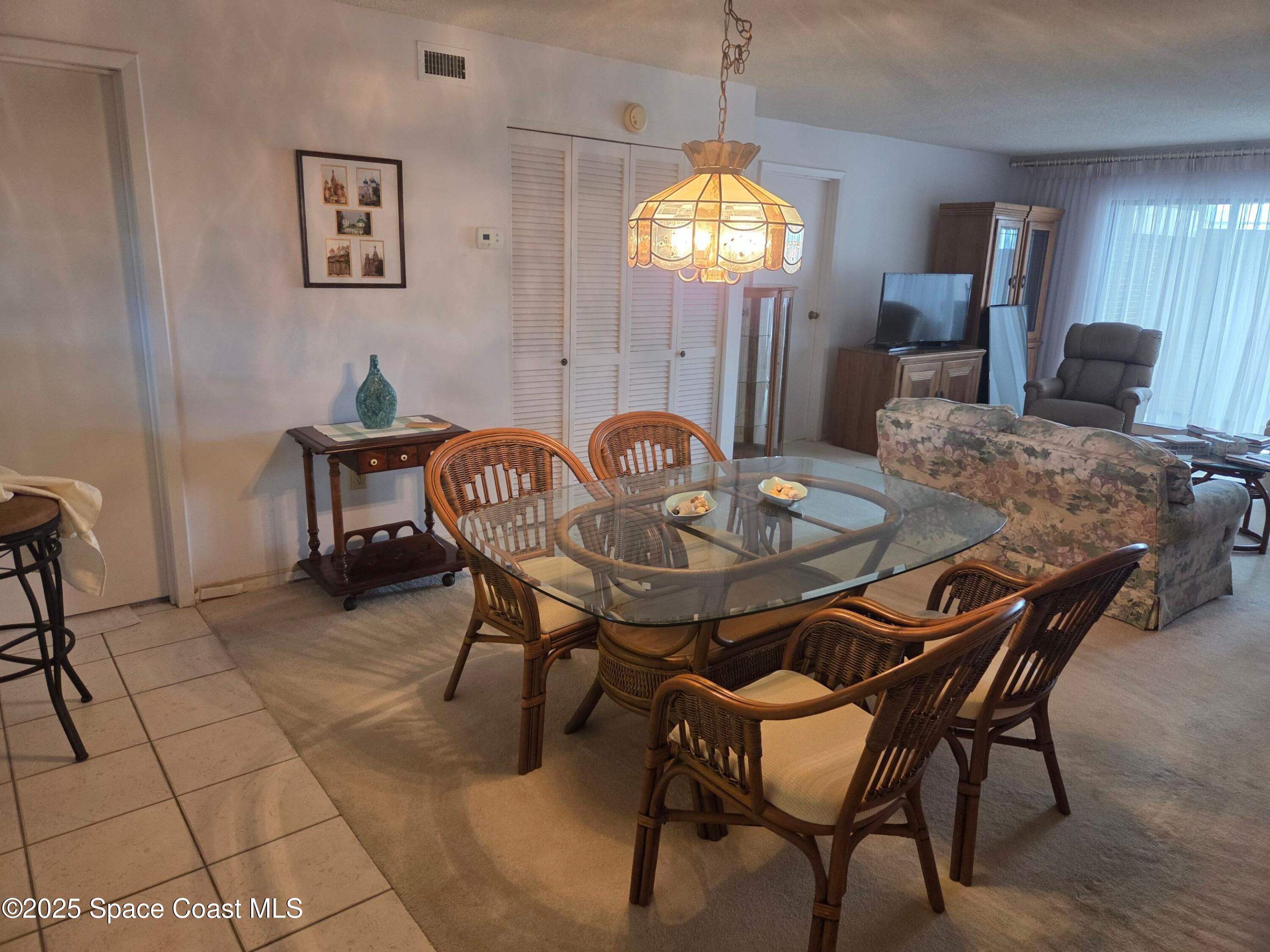 2727 North Wickham Road, Unit 20611 Melbourne, FL 32935 - Photo 2 of 10 a view of a dining room with furniture and chandelier