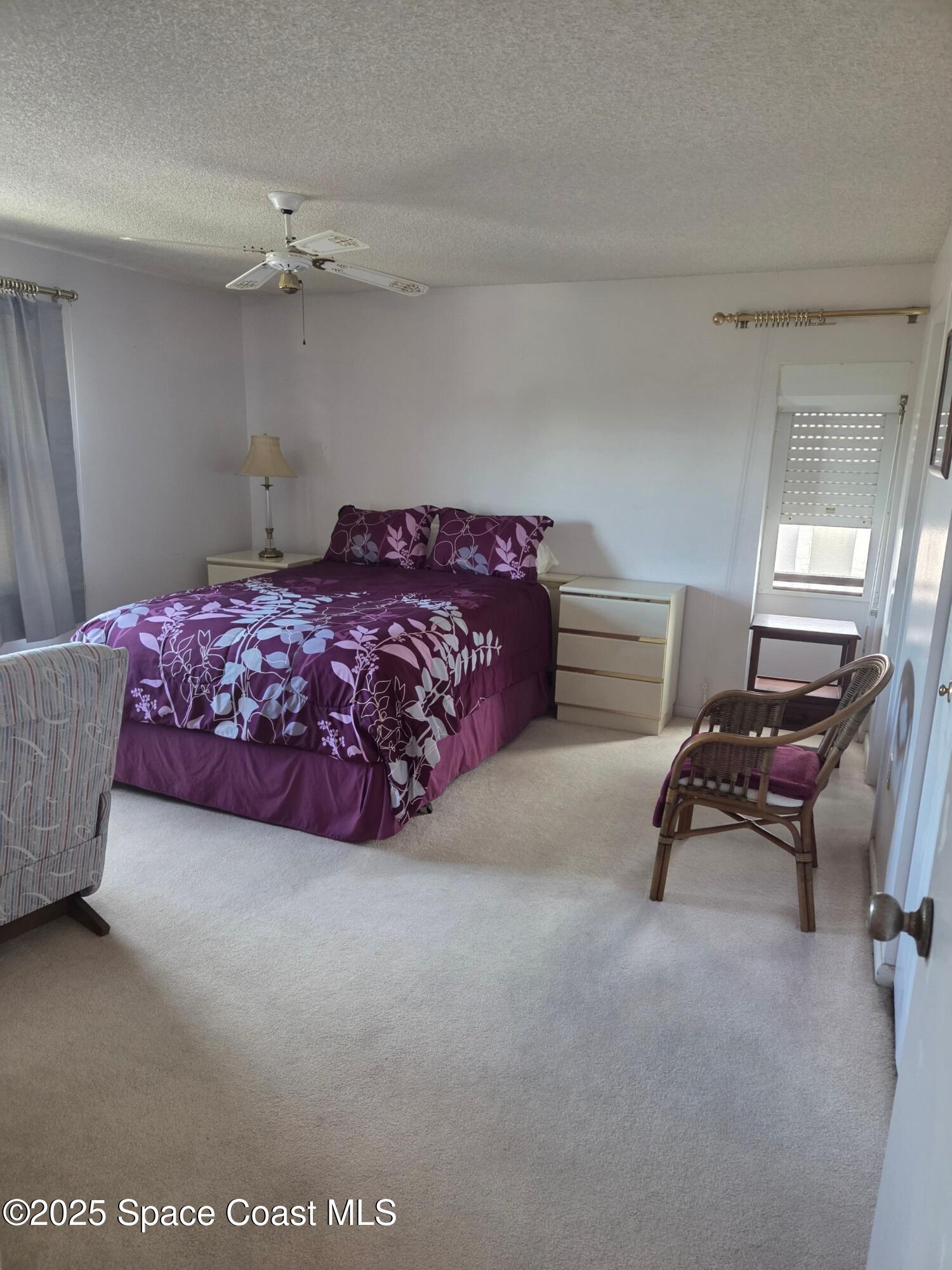 2727 North Wickham Road, Unit 20611 Melbourne, FL 32935 - Photo 2 of 10 a bedroom with a bed and a chandelier