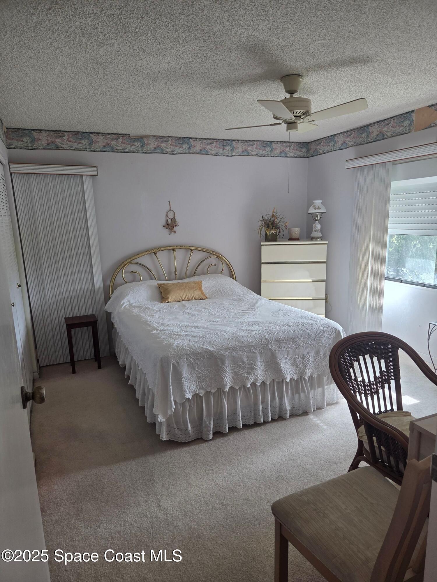 2727 North Wickham Road, Unit 20611 Melbourne, FL 32935 - Photo 3 of 10 a bedroom with a bed window and a chandelier