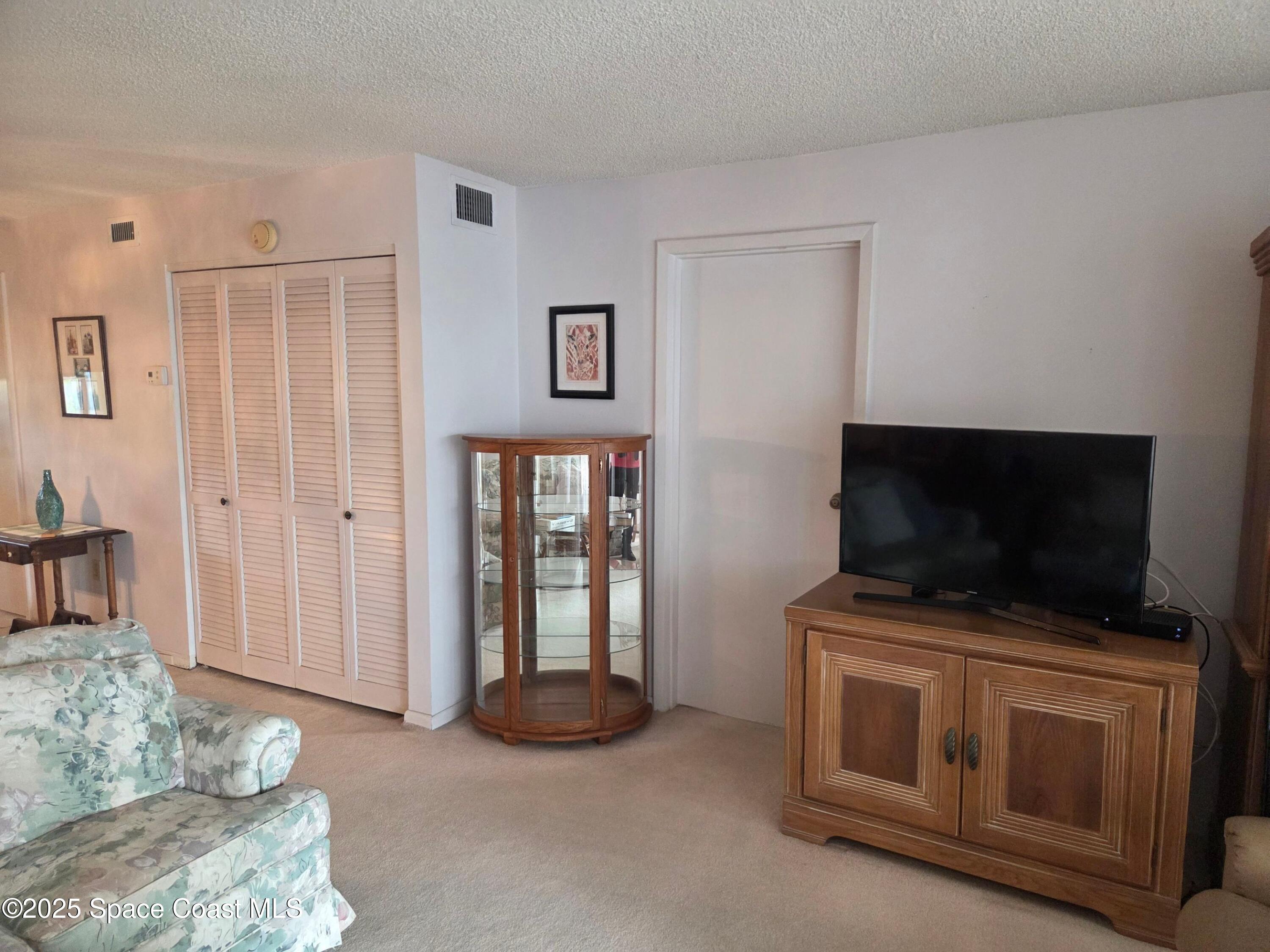 2727 North Wickham Road, Unit 20611 Melbourne, FL 32935 - Photo 3 of 10 a living room with furniture and a flat screen tv