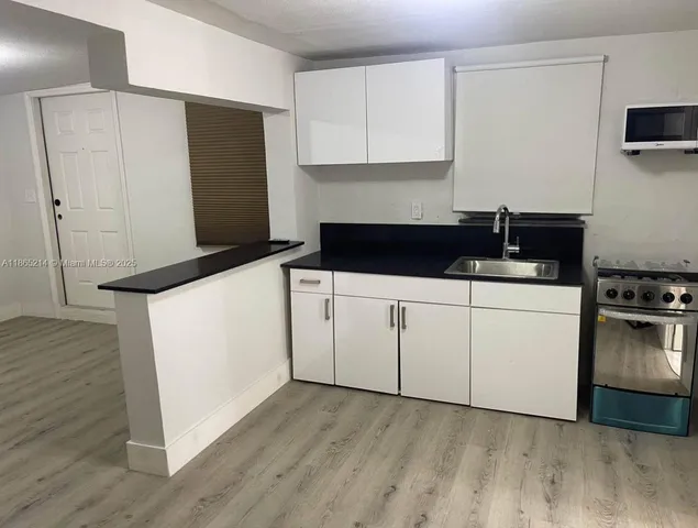 an empty room with wooden floor and mirror