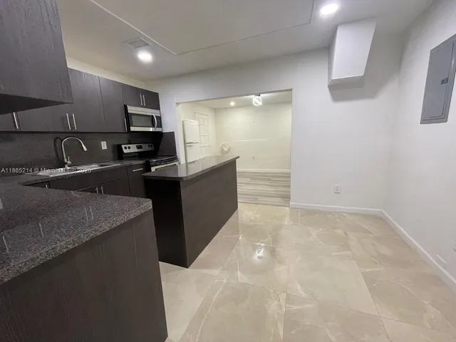 a kitchen with stainless steel appliances granite countertop a sink a stove and a refrigerator