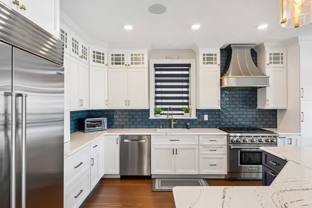 a kitchen with granite countertop a sink stainless steel appliances and cabinets